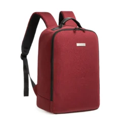3D angled front view of a burgundy minimalist backpack showing the smooth side zipper and clean lines. Trendy daily commuter bag by a leading Backpack Supplier.