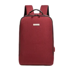 Front view of a minimalist burgundy backpack with a rectangular silver logo plate and top grab handle. Professional business bag by a Backpack Manufacturer.