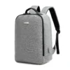 Slanted front view of a minimalist light grey business backpack with a sleek silver logo plate and a side charging port. Functional smart backpack by a Custom Backpack Manufacturer.
