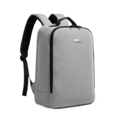 3D angled front view of a light grey minimalist backpack showing the smooth side zipper and clean lines. Trendy daily commuter bag by a leading Backpack Supplier.
