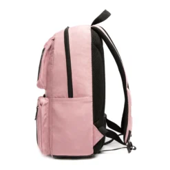 Side view of a dusty pink backpack showing its generous depth, smooth-running black zipper, and side pocket. Spacious daily commuter bag by a Backpack Manufacturer.