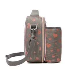 Side profile of a dark gray glitter heart lunch bag showing its depth, adjustable dark gray shoulder strap, and continuous rose gold print. High-density fabric bag by a Backpack OEM Supplier.