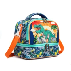 Slanted view of a blue dinosaur lunch bag featuring a front panel with a T-Rex and sunset design, silver star-shaped zipper pulls, and teal zipper details. Cool luxury cooler by a Backpack Supplier.