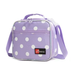 Slanted view of a pastel lavender polka dot lunch bag with a front zipper pocket, purple hardware, and a red logo patch. Functional trendy cooler by a Backpack Supplier.