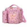 Slanted view of a pink glitter heart lunch bag with a matching detachable water bottle holder, heart-shaped zipper pulls, and a 3D bow patch. Functional luxury cooler by a Backpack Supplier.