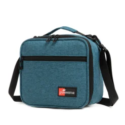 Slanted view of a deep teal textured lunch bag with a front zipper pocket and a red logo patch. Functional commuter cooler by a Backpack Supplier.