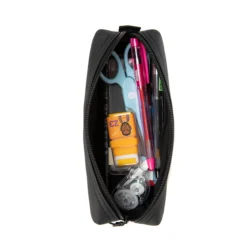 Open black pencil case filled with scissors, pens, and correction tape. Spacious stationery pouch by a Custom Backpack Manufacturer.
